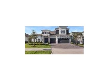 Beautiful two-story home with stone accents, manicured lawn, and a three-car garage at 4413 Lions Gate Ave, Clermont, FL 34711