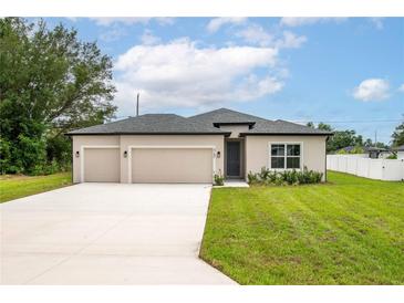 Charming single-story home with a manicured lawn and a two-car garage with neutral paint at 4780 Sw 129Th Pl, Ocala, FL 34473