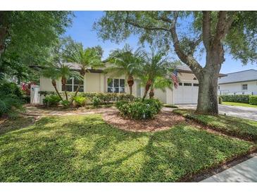 Charming home with a manicured lawn, mature trees, and palm trees at 489 Penny Ln, Maitland, FL 32751
