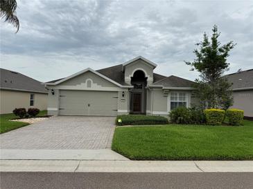 Charming home featuring a paver driveway, a two-car garage, and well-maintained landscaping at 541 Arena Dr, Davenport, FL 33837
