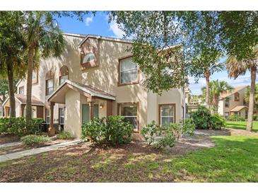 Inviting exterior view of a townhome featuring manicured landscaping and a charming entrance at 5436 E Michigan St # 7, Orlando, FL 32812