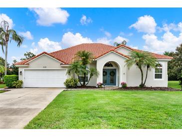 Charming single-story home featuring a red tile roof, attached garage and a beautifully manicured lawn at 6321 Clearmeadow Ct, Windermere, FL 34786
