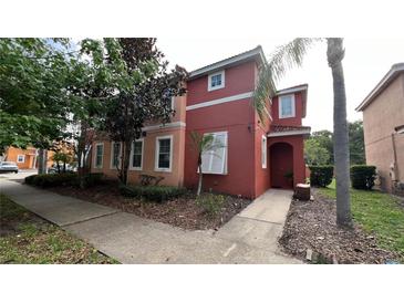 Two story townhouse with a stucco exterior and well-kept landscaping at 720 Las Fuentes Dr, Kissimmee, FL 34746