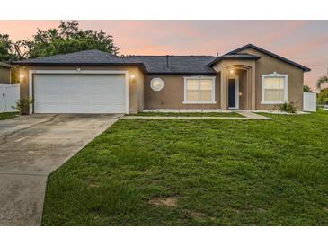 Charming single-story home with a well-maintained lawn and attached two-car garage, showcasing curb appeal at 112 Lake Butler Ave, Haines City, FL 33844