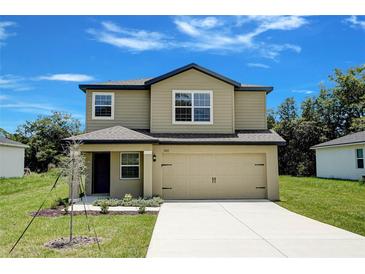 Two-story home featuring a beige exterior, attached two-car garage, and well-maintained front lawn at 1303 Congo Ct, Kissimmee, FL 34759