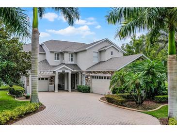 Stunning two-story home with lush landscaping and circular brick driveway and a three-car garage at 14038 Bluebird Park Rd, Windermere, FL 34786