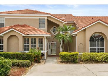 Inviting front exterior of home featuring a red tile roof, stucco facade, and lush landscaping at 1705 Saint Tropez Ct, Kissimmee, FL 34744