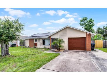 Charming single-story home featuring a brick and siding exterior, solar panels, and a well-manicured lawn at 2809 Redditt Rd, Orlando, FL 32822