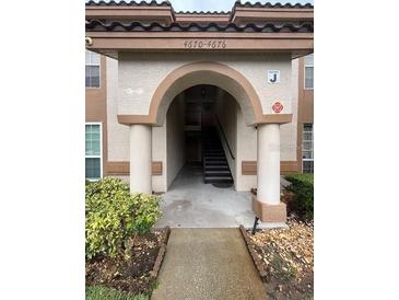 Inviting entrance with classic architectural details, pillars, and an arched entryway at 4674 Pembrook Pl # J 101, Orlando, FL 32811