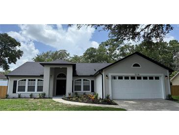 Charming single-story home featuring a well-manicured lawn and a two-car garage at 5118 Log Wagon Rd, Ocoee, FL 34761