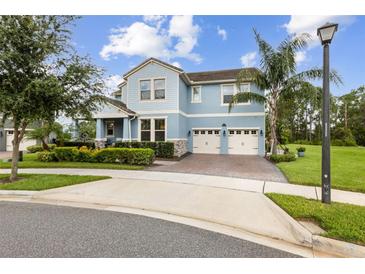 Charming two-story home features a well-manicured lawn, two-car garage, and inviting light blue color at 9844 Beach Port Dr, Winter Garden, FL 34787