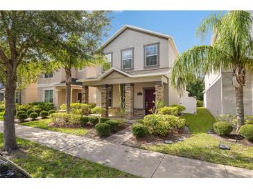Charming two-story home featuring stone accents, a landscaped yard, and a welcoming covered front porch at 15229 Evergreen Oak Loop, Winter Garden, FL 34787