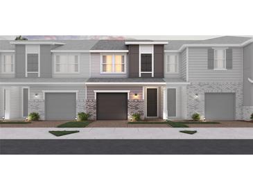 Charming townhome featuring a brick and siding facade, garage, and well-manicured landscaping at 1689 Greenleaf Woods Cv, Oviedo, FL 32765