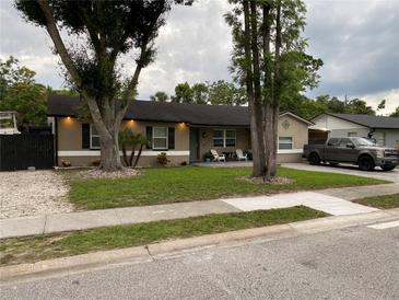 Charming single story home with a lawn, mature trees, dark shutters, and outdoor seating area on the front porch at 170 N Fairfax Ave, Winter Springs, FL 32708