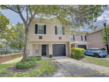 Charming two-story townhome featuring a front-entry garage and lush landscaping at 2901 Ashford Park Pl, Oviedo, FL 32765
