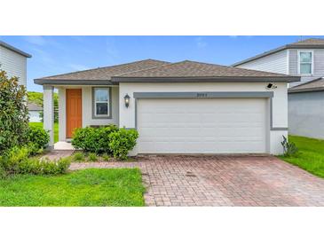 Charming single-story home with a two-car garage and well-maintained landscaping at 29783 Anahid Dr, Leesburg, FL 34748