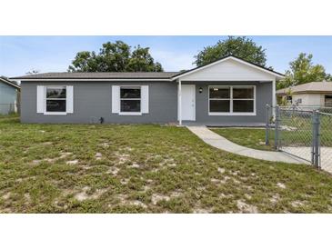 Charming single-story home with a gray exterior, white trim, and a well-maintained front yard at 325 Little Aspen Ct, Ocoee, FL 34761