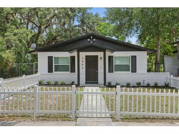 Charming home with a white picket fence, black trim, and beautiful curb appeal at 1002 Cypress Ave, Sanford, FL 32771