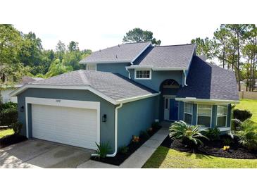 Charming two-story home featuring a well-manicured lawn and a two-car garage at 10747 Satinwood Cir, Orlando, FL 32825