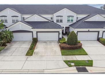 Charming townhome with a well-manicured lawn, private garages, and a neatly landscaped yard at 1275 Shallcross Ave, Orlando, FL 32828
