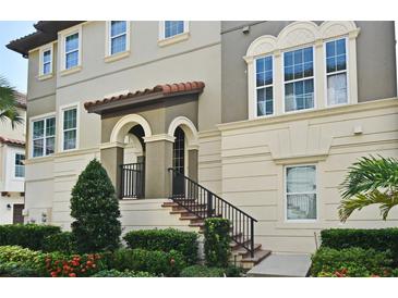 Elegant home exterior featuring a covered entryway, manicured landscaping, and a welcoming staircase at 312 Trieste Loop, Lake Mary, FL 32746