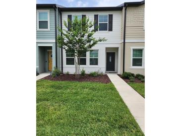 Charming two-story townhome featuring a landscaped front yard and inviting entrance at 3248 Merton Aly, Orlando, FL 32808
