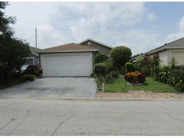 Charming single-story home with a well-maintained lawn and two-car garage at 5224 Florida Holly Dr, Orlando, FL 32811