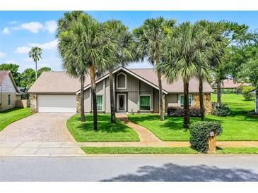 Charming home featuring palm trees, a brick driveway and walkway, and a well-maintained lawn at 526 Sabal Trail Cir, Longwood, FL 32779