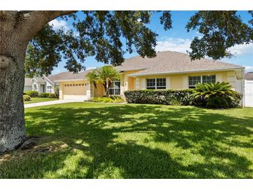 Inviting single-story home featuring a well-manicured lawn, mature landscaping, and a welcoming facade at 6005 Coal Ct, St Cloud, FL 34772