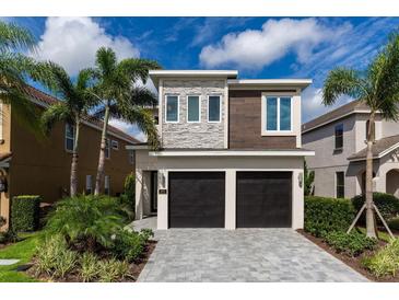 Beautiful two-story home featuring a modern design, manicured landscaping, and a two-car garage, making it a perfect Gathering residence at 884 Golden Bear Dr, Reunion, FL 34747