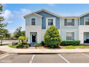 Charming two-story townhome featuring a well-maintained lawn and inviting front entrance at 8900 Sydney Ave, Kissimmee, FL 34747