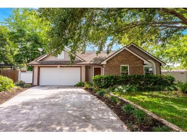 Charming single-story home with brick and siding, mature landscaping, and a two-car garage at 1010 Leinhart Ct, Oviedo, FL 32765