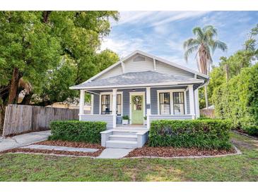 Charming single-story home with a well-manicured lawn, inviting porch, and a vibrant green front door at 112 E Spruce St, Orlando, FL 32804