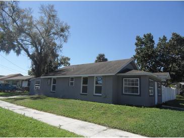 Charming single-story home with a well-manicured lawn, sidewalk and mature trees at 1600 Roosevelt Ave, Orlando, FL 32804