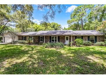 Charming brick ranch home with a well-manicured lawn and mature landscaping at 220 Morton Ln, Winter Springs, FL 32708