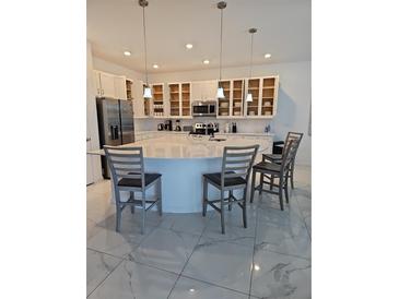 Modern kitchen featuring a large island, stainless steel appliances, and open shelving at 2496 Rama Dr, Kissimmee, FL 34746