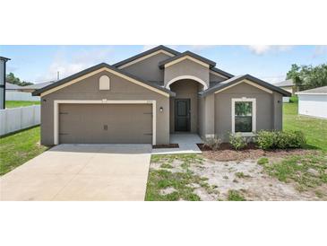 Charming home featuring a two-car garage and covered entryway for curb appeal at 257 Fig Ct, Kissimmee, FL 34759