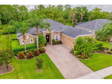 Beautiful single-story home with lush landscaping, brick driveway, and stone accents at 3753 Heirloom Rose Pl, Oviedo, FL 32766