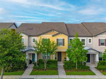 Townhome with meticulously maintained lawn, shrubs and tidy landscaping around the walkway at 5029 Walker St, St Cloud, FL 34771