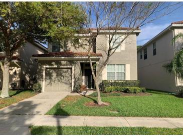 Charming two-story home with a well-manicured lawn, complemented by a two car garage and mature shade trees at 8894 Candy Palm Rd, Kissimmee, FL 34747