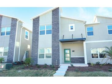 Modern two-story home with stone accents and well-maintained landscaping at 976 Leader St, Davenport, FL 33896