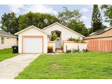 Charming single-story home with attached garage, vibrant landscaping and a well-manicured lawn at 9814 Piney Point Cir, Orlando, FL 32825