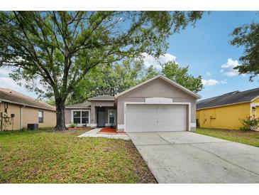 Charming single-story home featuring a well-maintained lawn and attached two-car garage at 14565 Lycastle Cir, Orlando, FL 32826