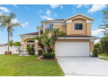 Charming two-story home with lush landscaping, palm trees, and a beautiful fountain at 344 Blue Bayou Dr, Kissimmee, FL 34743