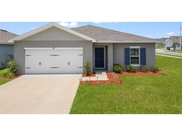 Charming single-story home featuring a well-maintained lawn and attached two-car garage at 489 Panaro Ln, Haines City, FL 33844