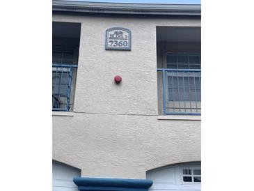Building exterior featuring building number 7360 and small blue balconies at 7360 Westpointe Blvd # 114, Orlando, FL 32835