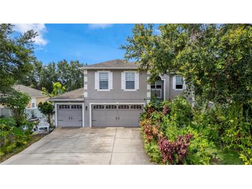 Charming two-story home featuring a well-manicured front yard and an attached two-car garage at 7642 Park Hill Ave, Leesburg, FL 34748