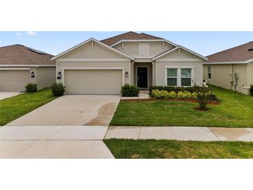 Charming single-story home with a well-manicured lawn and attached two-car garage at 884 Laurel View Way, Groveland, FL 34736