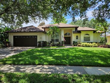 Charming single-story home featuring a well-manicured lawn, lush landscaping, and a welcoming front entrance at 9491 Wickham Way, Orlando, FL 32836