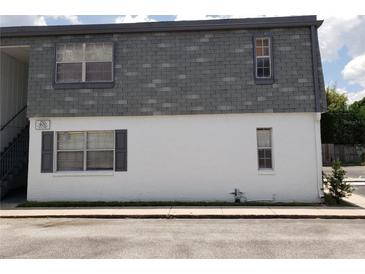 The exterior of the building shows a gray roof and a white lower level, with windows and landscaping at 1000 S Semoran Blvd # 415, Winter Park, FL 32792